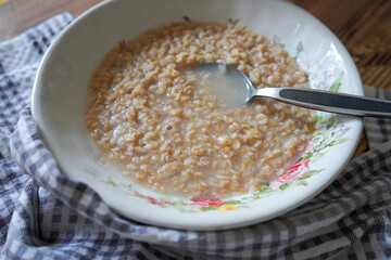 Plain oatmeal porridge in bowl. Healthy vegan vegetarian breakfast food, whole grain