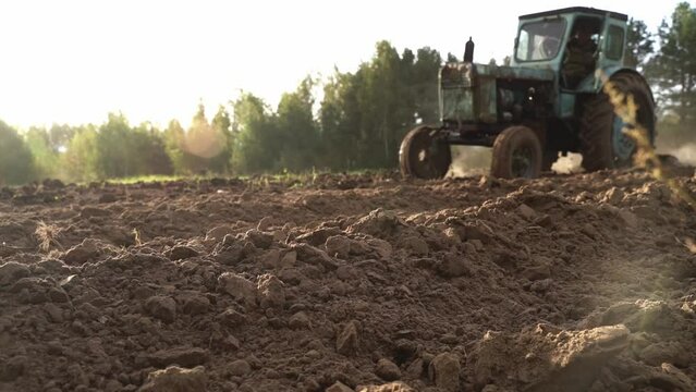 selective focus. a peasant plows the land on a tractor