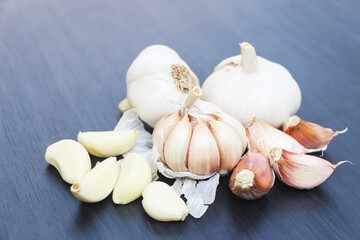 White raw garlic on black wood floor