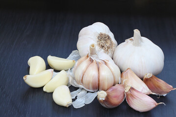 White raw garlic on black wood floor