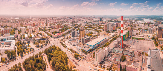 Aerial cityscape urban view with CHP pipe among city streets and buildings