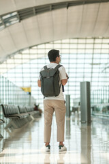 Young male wearing face mask with bagckpack walking in airport, protection Coronavirus disease...