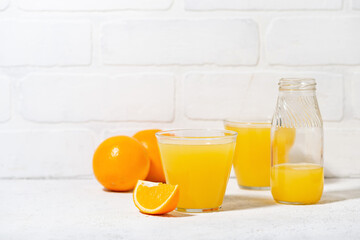 glasses of freshly squeezed orange juice on a white background