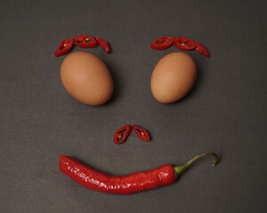 The combination of fresh tomatoes, red chilies and eggs forms a smiling face. Cooking ingredients...