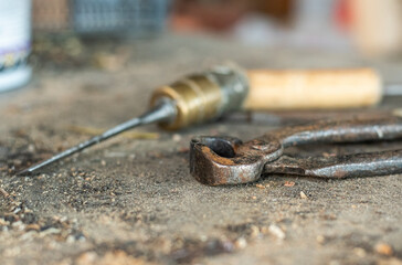 selective focus. old metal tools such as wire cutters, chisel on an old dusty table