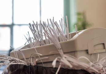 office shredder with overflowing cut paper
