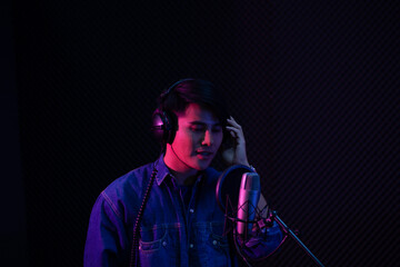 Asian male singer recording in the studio.