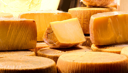 aged cheese for sale in the dairy stall at the market with cellophane