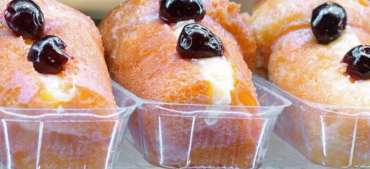 three large rum liqueur babas with cherries on a typical traditional dessert