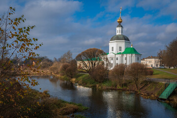 Fototapeta na wymiar View of the Vyazma Museum of Local History located in the Bogoroditskaya Church on the banks of the Vyazma River on a sunny autumn day with clouds, Vyazma, Smolensk region, Russia