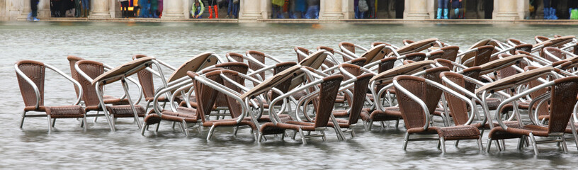 table and chairs of the alfresco cafe under water in Piazza San Marco during a terrible flood in...