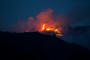 Flames and smoke on the mountain side at the Indian Gulch Fire. March 3rd, 2011 in Golden, Colorado.