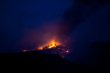 Flames and smoke on the mountain side at the Indian Gulch Fire. March 3rd, 2011 in Golden, Colorado.