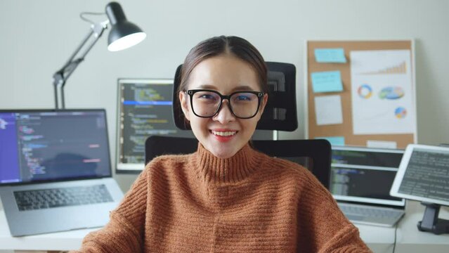 Portrait young Asian woman developer programmer, software engineer, IT support, wearing glasses look at camera and smile enjoy working at home.