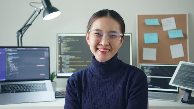 Portrait young Asian woman developer programmer, software engineer, IT support, wearing glasses look at camera and smile enjoy working at home.