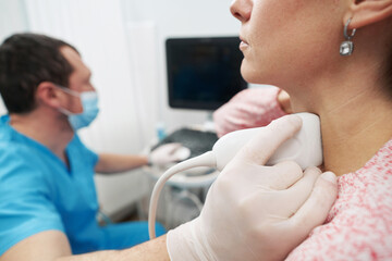 Young woman undergoing an examination of thyroid gland at the endocrinolodist
