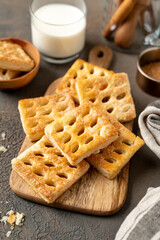 Puff cookies on a serving wooden board on a dark culinary background. Delicious homemade sweet pastries