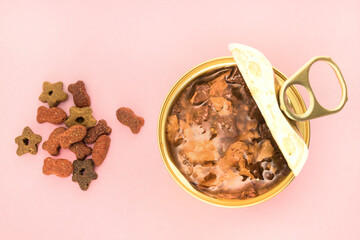 Canned meat with sauce decorated and dry pet foods on pink background. Various types of pet foods....