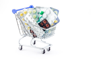 Medical concept of shopping cart fully filled with packaged pills isolated on white background. Various pills in blister packages. Ideas for healthcare, shopping in pharmacies