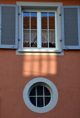 Fenster wirft Schatten auf eine Altbaufassade