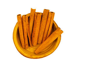 Cinnamon sticks in wooden bowl on white background with copy space