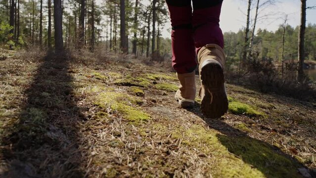 Woman hiking in the mountain. View of hiking boots on forest.