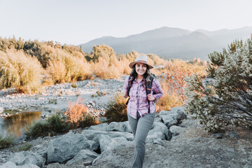 Naklejka na ściany i meble Young single traveler woman with a backpack on, doing trekking to explore nature. Single Hiking
