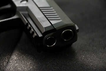 Automatic 9mm pistol gun on black leather background, soft and selective focus.