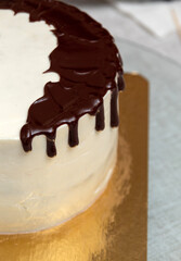 Chocolate smudges on the cake with white cream. Close-up. View from above. Selective focus. Images for articles about desserts and confectionery.