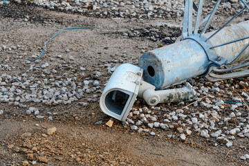 Broken CCTV camera laying on the ground. Concept of surveillance is not protecting people