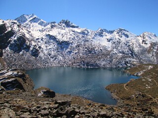 Lake in the mountains. Lake landscape. View of Gosaikunda Lake in the Himalayas . Blue sky. Beautiful Day. Reflection in the Water. Gosainkunda in Langtang National Park, Nepal