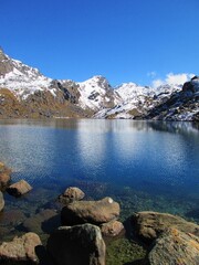 View of Gosaikunda Lake. Sunny Day in the Himalayas, Langtang Trek in the Mountains. Peaks reflection in the water. Gosainkunda in Langtang National Park, Rasuwa Disctict, Nepal