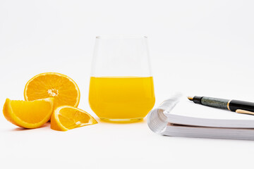 Glass of orange juice with a notebook