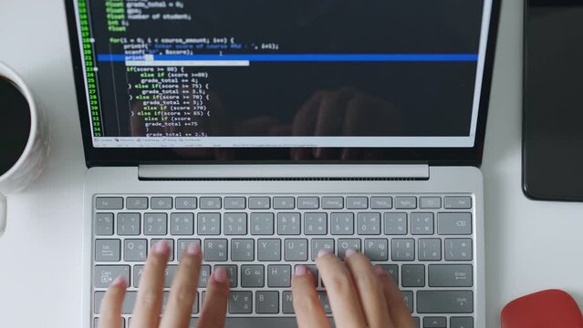 Developer programmer working on computer laptop, typing keyboard, to check coding in bugging system. Top view