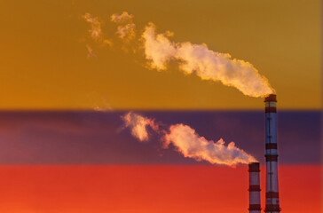 Obraz premium Against the background of the flag of Colombia, smoke is emitting from the pipes of the enterprise, polluting the air.