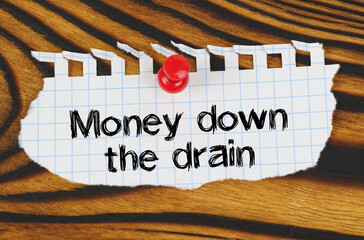 Attached to the board is an announcement with the inscription - Money down the drain