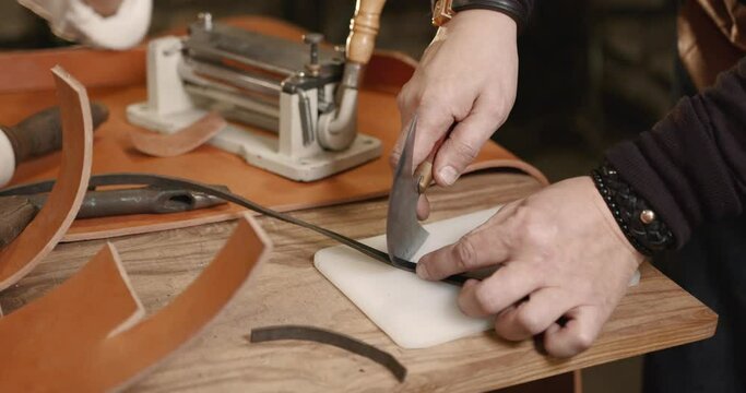 Master making leather belt in a workshop