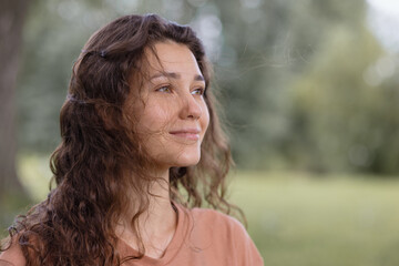 a woman with curly hair meditates in the park. yoga and meditation for mental and physical health....