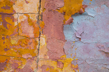 Multicolour shabby concrete wall with flaky plaster. Vintage, cracked distressed background. Abstract painting colorful backdrop. Abstract pattern. Cracked painted texture of dilapidated building.