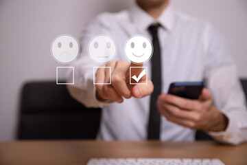 Businessman pressing smiley face emoticon on virtual touch screen