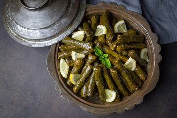 Delicious dolma (sarma) stuffed grape leaves rice, white yogurt sauce. Lebanese dolma sarma on plate. Lebanon turkish greek middle eastern cuisine. (Turkish name; Yaprak sarma)