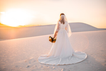 Fototapeta na wymiar Bride watching sunset at White Sands National Park, wide portrait