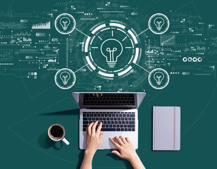 Idea light bulb theme with person using a laptop computer