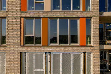 Closeup aerial of partly finished exterior facade in Zutphen of real estate investment and social housing market collective building project. Dutch engineering real estate investment urban development