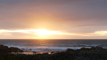 Rocky craggy pacific ocean coast, sea water waves crashing, 17-mile drive, Monterey California USA. Dramatic sunset sky nature near Point Lobos, Big Sur and Pebble beach. Seamless looped cinemagraph.