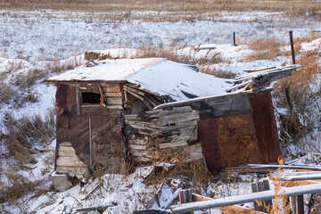 An outbuilding destroyed by an explosion against the background of melting spring snow.