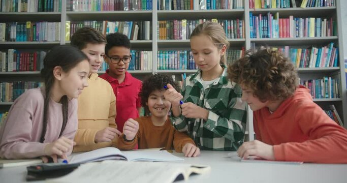 Multinational kids surround boy with kinky hair in library