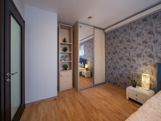 Interior of bedroom in modern apartment. Wooden wardrobe. with mirror.