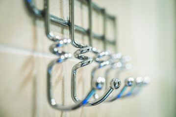 Metal hanger with many hooks for towels and clothes. Close-up.
