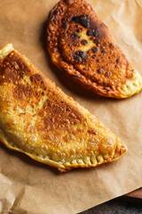 Homemade juicy golden deepfried turnovers chebureks on baking paper. Traditional Turkic-Mongolian dish. Street food